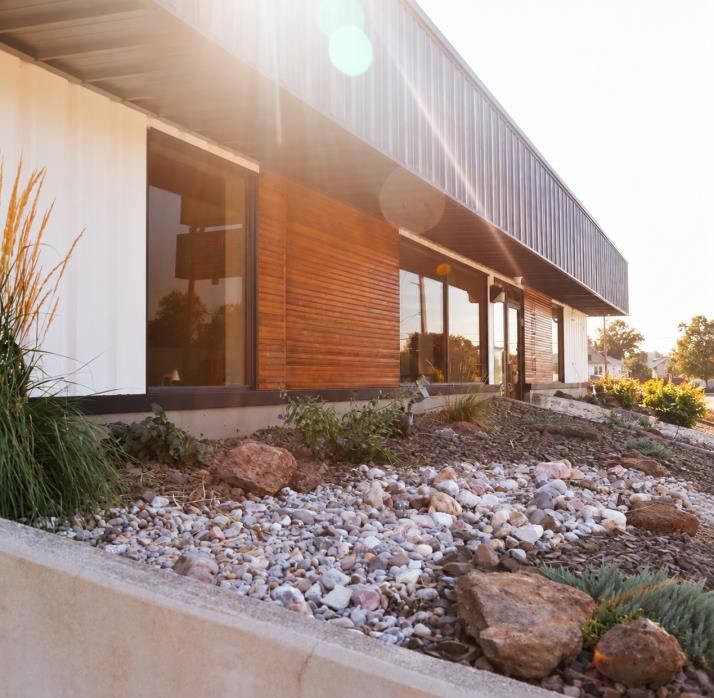 Wood-clad exterior of Inland Studios with landscaped planting beds in Spokane
